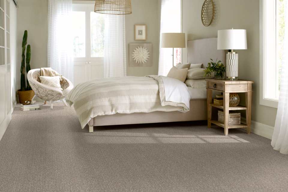 patterned gray carpet in monochromatic bedroom with rattan lighting and artwork